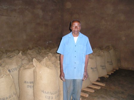 A member of the Mamsera RCS proudly showing warehoused coffee ready to depositing under WRS